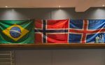 an image of three flags - Brazil, Norway, and Finland, hanging above a wall in the Petherwick Jiu Jitsu Dojo